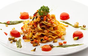 Tagliatelle vegetariane con pesto di rucola e pomodorini al forno