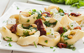 Tortelloni con feta, pinoli e pomodori secchi